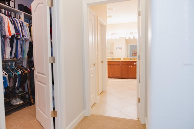 hall with a sink and light tile patterned floors