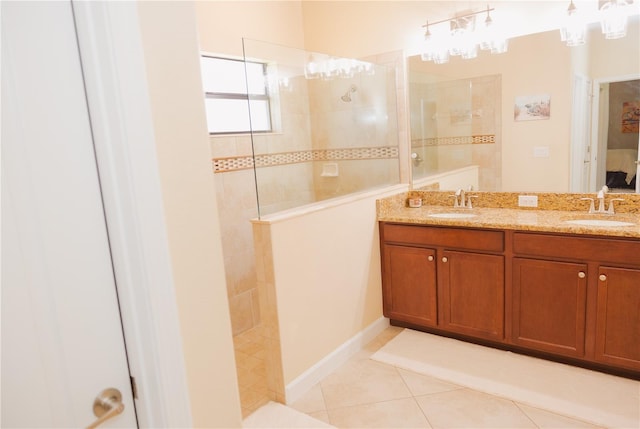 ensuite bathroom featuring tile patterned flooring, a sink, a walk in shower, and double vanity