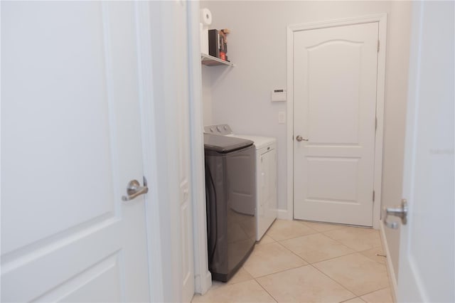 laundry area with laundry area, independent washer and dryer, and light tile patterned flooring