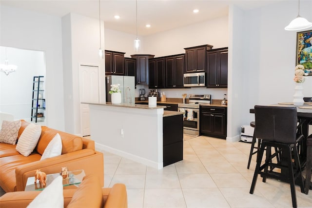 kitchen with pendant lighting, light tile patterned floors, open floor plan, and stainless steel appliances