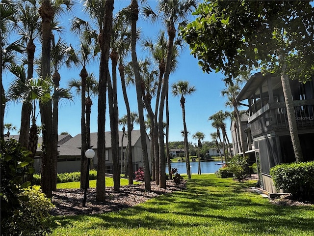 view of home's community with a lawn and a water view