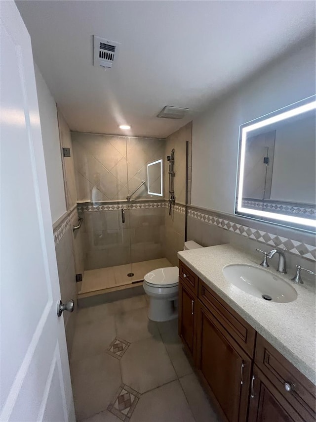 full bathroom featuring tile patterned floors, toilet, tile walls, a stall shower, and visible vents
