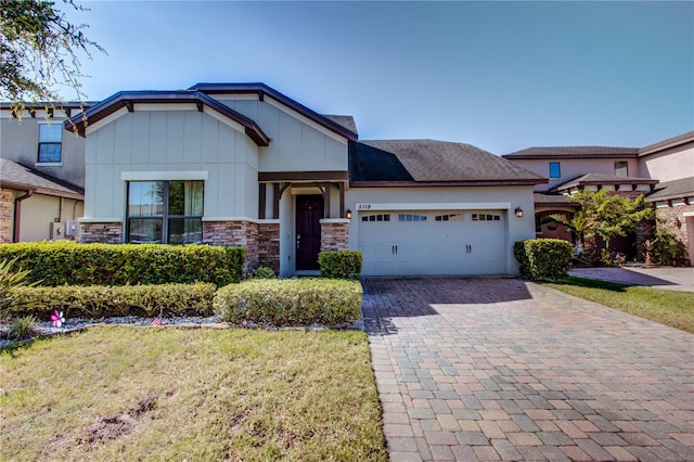 5118 Tiber Way, Saint Cloud, FL 34771 - craftsman house with an attached garage, stone siding, a front yard, and decorative driveway