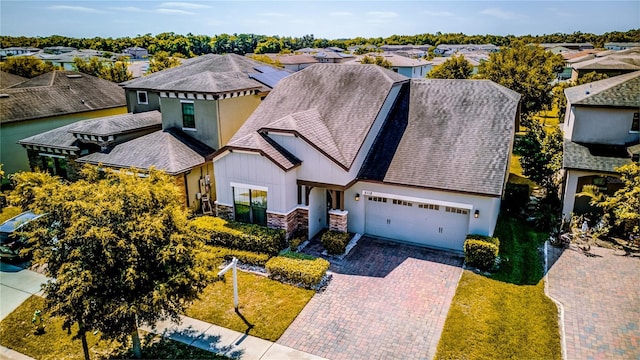 5118 Tiber Way, Saint Cloud, FL 34771 - view of front of home featuring decorative driveway, a garage, stone siding, a front yard, and a residential view