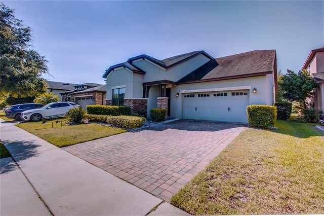5118 Tiber Way, Saint Cloud, FL 34771 - view of front of property with a front lawn, decorative driveway, stone siding, and an attached garage