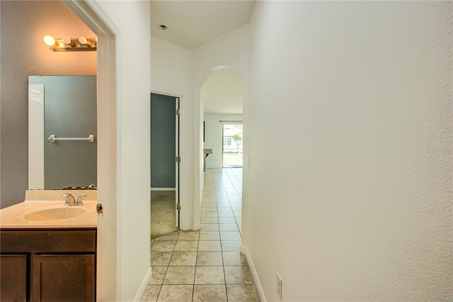 5118 Tiber Way, Saint Cloud, FL 34771 - hall featuring baseboards, arched walkways, a sink, and light tile patterned floors