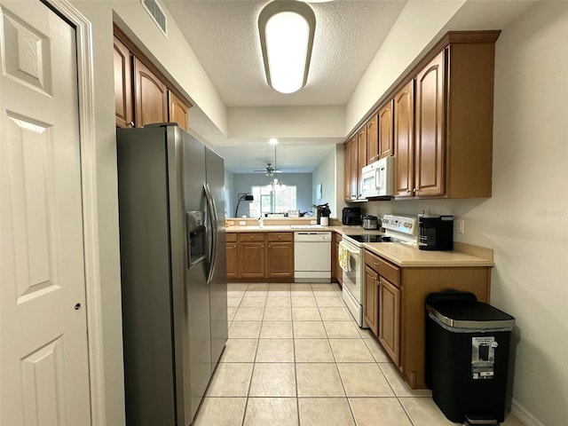 9435 Myrtle Creek Ln Unit 304, Orlando, FL 32832 - kitchen featuring light countertops, visible vents, white appliances, light tile patterned flooring, and a textured ceiling
