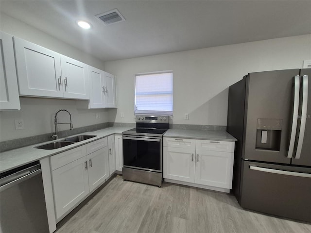 139 Arroyo Pkwy, Ormond Beach, FL 32174 - kitchen with white cabinets, light wood finished floors, stainless steel appliances, visible vents, and a sink