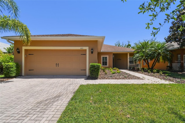 523 Shell Creek St, Poinciana, FL 34759 - view of front of home featuring an attached garage, a front lawn, driveway, and stucco siding