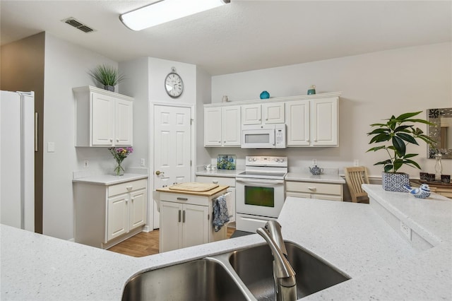 523 Shell Creek St, Poinciana, FL 34759 - kitchen with white cabinets, visible vents, a sink, and white appliances