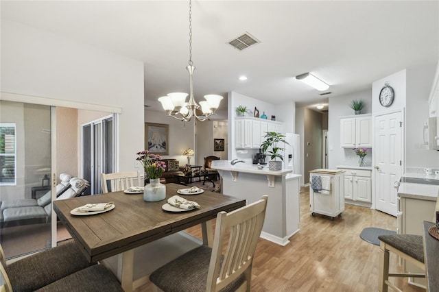523 Shell Creek St, Poinciana, FL 34759 - dining area with light wood-type flooring, visible vents, and an inviting chandelier