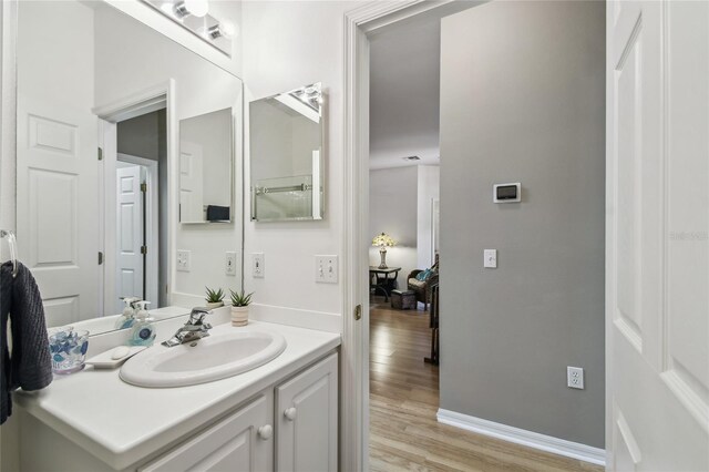 523 Shell Creek St, Poinciana, FL 34759 - bathroom featuring baseboards, wood finished floors, and vanity