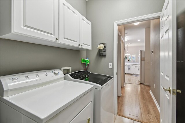 523 Shell Creek St, Poinciana, FL 34759 - laundry room featuring washing machine and clothes dryer, light wood-style floors, and cabinet space