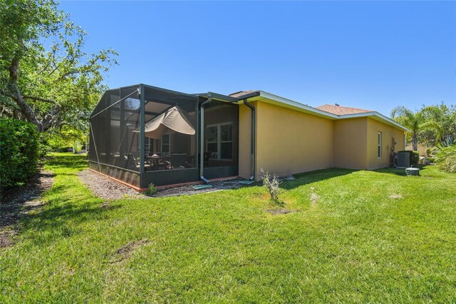 523 Shell Creek St, Poinciana, FL 34759 - back of property with a lawn, central AC, and stucco siding