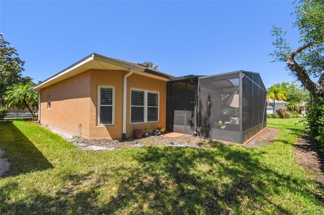 523 Shell Creek St, Poinciana, FL 34759 - rear view of property featuring stucco siding, a sunroom, and a lawn