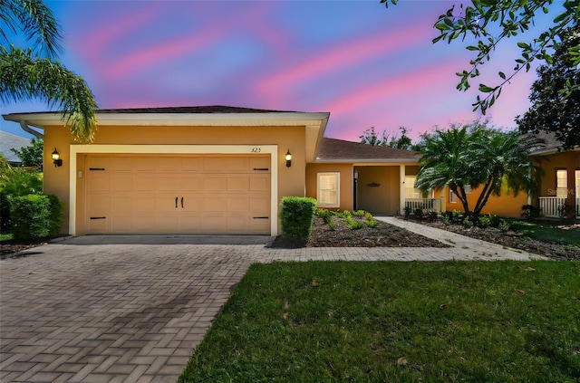 523 Shell Creek St, Poinciana, FL 34759 - view of front of property with an attached garage, stucco siding, and decorative driveway