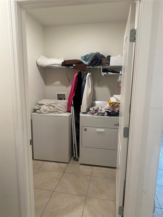 laundry area with washer and dryer, laundry area, and light tile patterned flooring