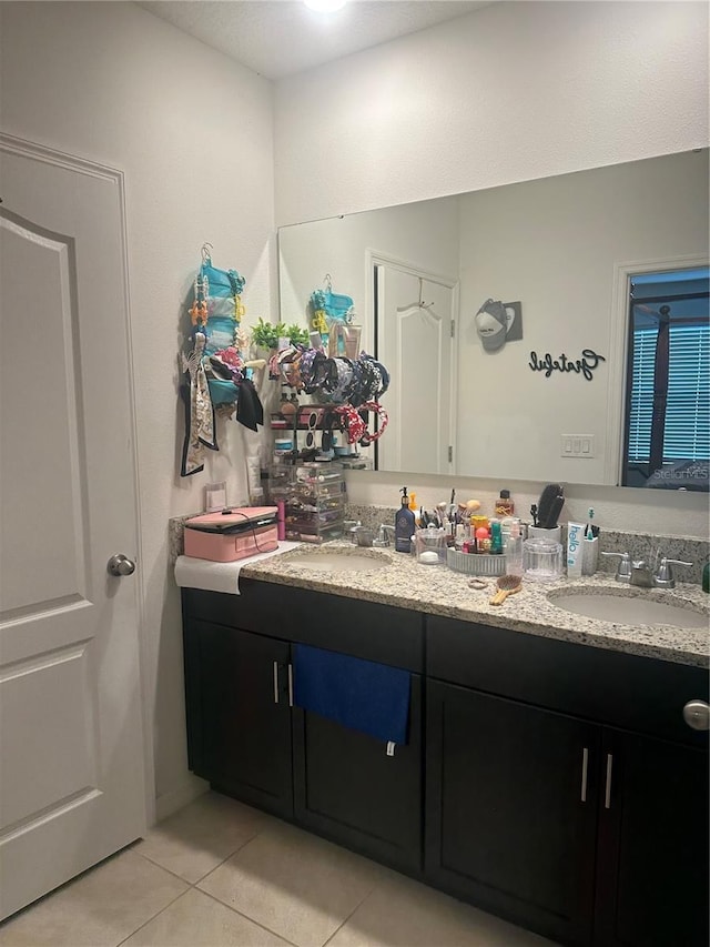 bathroom with tile patterned floors, a sink, and double vanity