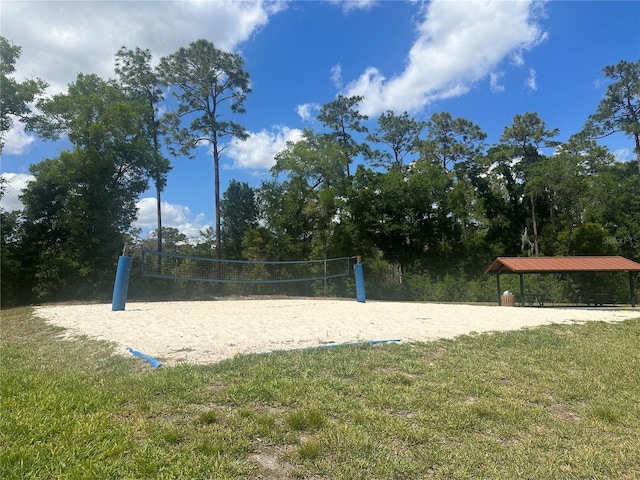 surrounding community with a yard and volleyball court