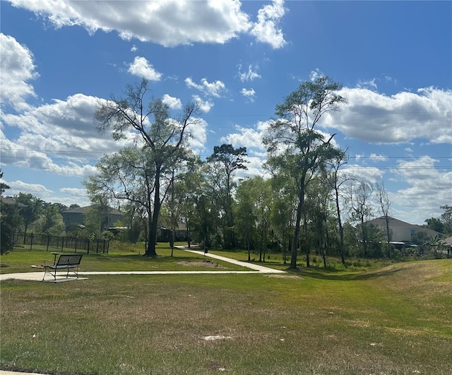 surrounding community featuring fence and a yard