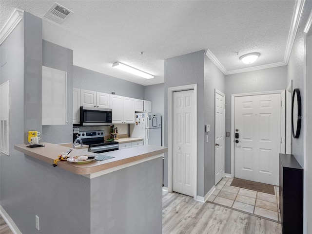 18001 Richmond Place Dr Unit 126, Tampa, FL 33647 - kitchen featuring stainless steel appliances, a peninsula, light countertops, white cabinets, and light wood-type flooring