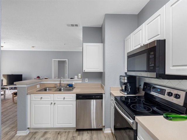 18001 Richmond Place Dr Unit 126, Tampa, FL 33647 - kitchen with appliances with stainless steel finishes, a peninsula, white cabinets, and light countertops