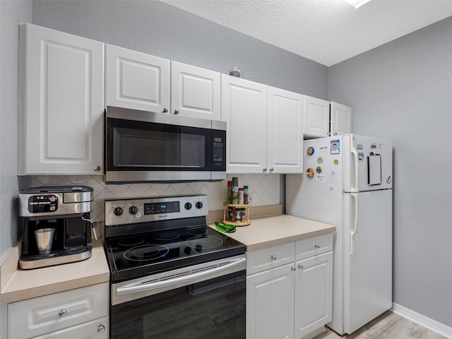 18001 Richmond Place Dr Unit 126, Tampa, FL 33647 - kitchen featuring appliances with stainless steel finishes, light countertops, decorative backsplash, white cabinetry, and a textured ceiling