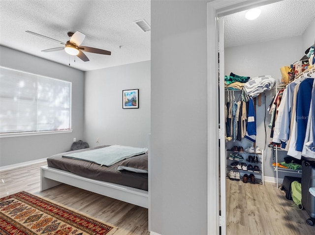 18001 Richmond Place Dr Unit 126, Tampa, FL 33647 - bedroom featuring a textured ceiling, wood finished floors, ceiling fan, and a closet