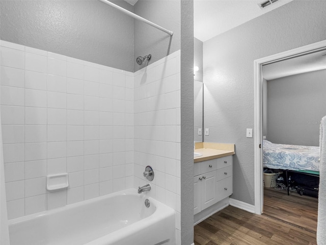 18001 Richmond Place Dr Unit 126, Tampa, FL 33647 - full bath featuring a textured wall, shower / bathtub combination, wood finished floors, vanity, and connected bathroom