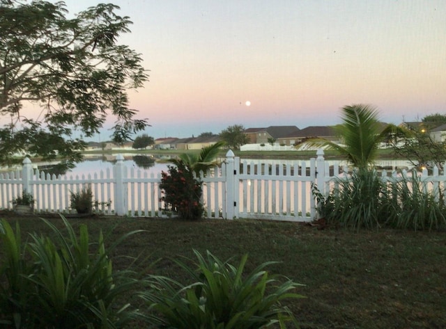 954 Hacienda Cir, Kissimmee, FL 34741 - yard at dusk featuring fence and a water view