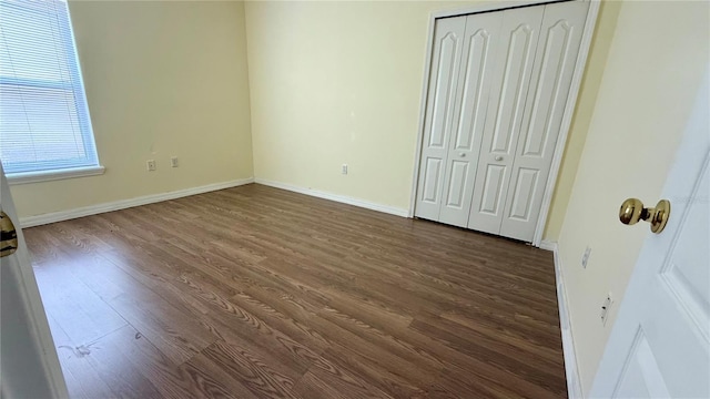 954 Hacienda Cir, Kissimmee, FL 34741 - unfurnished bedroom with dark wood finished floors, baseboards, and a closet