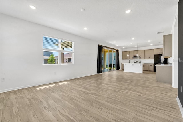 1003 Sugarwood St, Davenport, FL 33837 - unfurnished living room with baseboards, light wood-style floors, visible vents, and recessed lighting