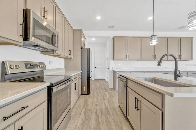 1003 Sugarwood St, Davenport, FL 33837 - kitchen with hanging light fixtures, a sink, light wood-type flooring, appliances with stainless steel finishes, and visible vents