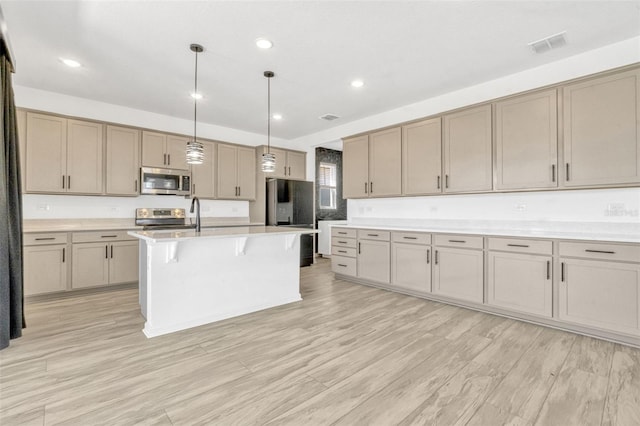 1003 Sugarwood St, Davenport, FL 33837 - kitchen with light countertops, visible vents, a kitchen bar, hanging light fixtures, and appliances with stainless steel finishes