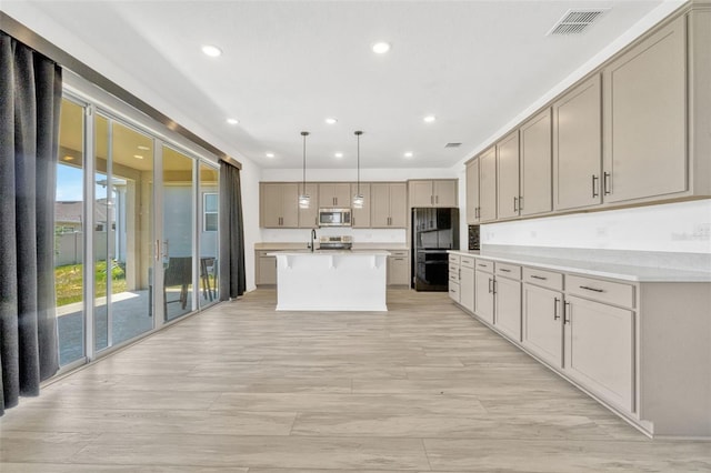 1003 Sugarwood St, Davenport, FL 33837 - kitchen featuring stainless steel appliances, visible vents, recessed lighting, light countertops, and an island with sink