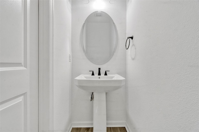 1003 Sugarwood St, Davenport, FL 33837 - bathroom featuring a textured wall, wood finished floors, and baseboards