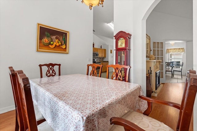 2289 Jessica Ln, Kissimmee, FL 34744 - dining space featuring light wood finished floors, baseboards, and arched walkways