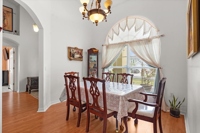 2289 Jessica Ln, Kissimmee, FL 34744 - dining room featuring light wood-type flooring, baseboards, arched walkways, and a notable chandelier