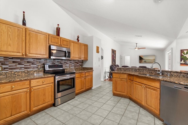 2289 Jessica Ln, Kissimmee, FL 34744 - kitchen with lofted ceiling, backsplash, a sink, appliances with stainless steel finishes, and ceiling fan