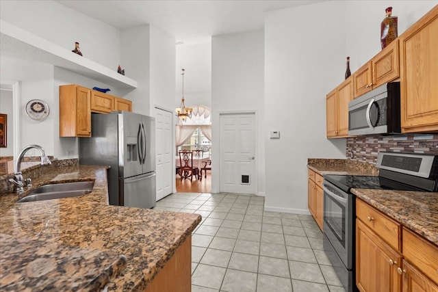 2289 Jessica Ln, Kissimmee, FL 34744 - kitchen featuring a sink, a towering ceiling, backsplash, appliances with stainless steel finishes, and light tile patterned floors