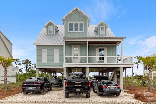 coastal home with a porch, stairs, a carport, and metal roof