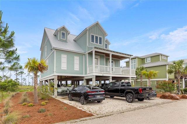 raised beach house featuring a carport, board and batten siding, and metal roof