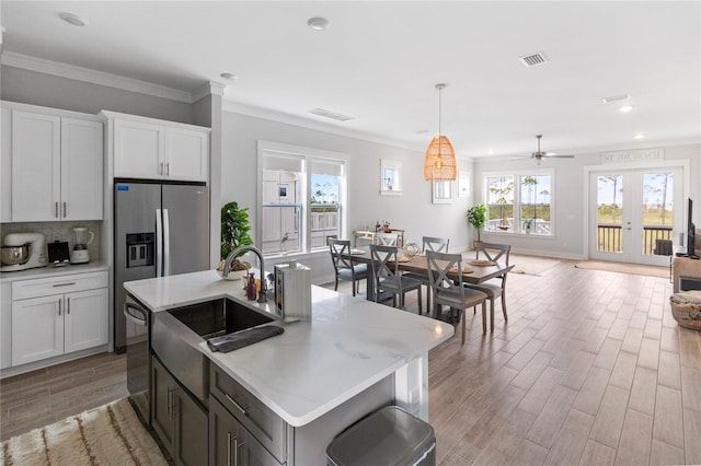 kitchen with dishwasher, open floor plan, light wood-type flooring, baseboards, and white cabinetry