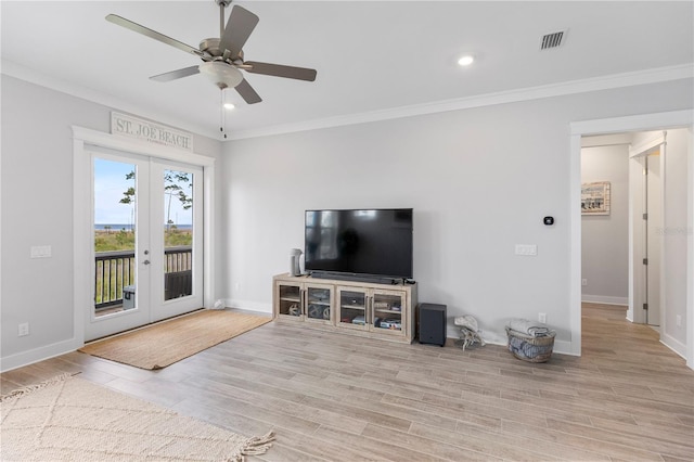 living room with french doors, crown molding, baseboards, ceiling fan, and wood finished floors