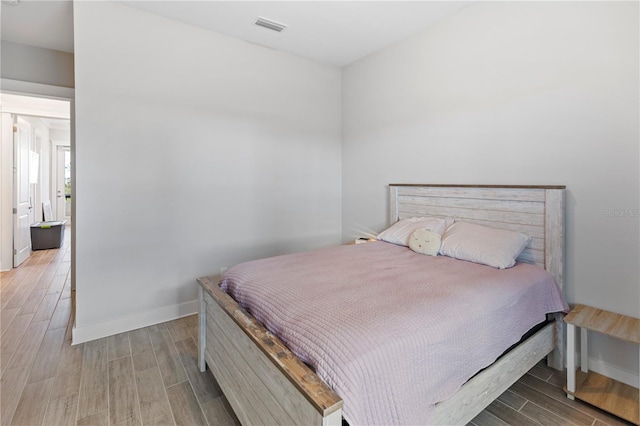 bedroom with light wood finished floors and baseboards