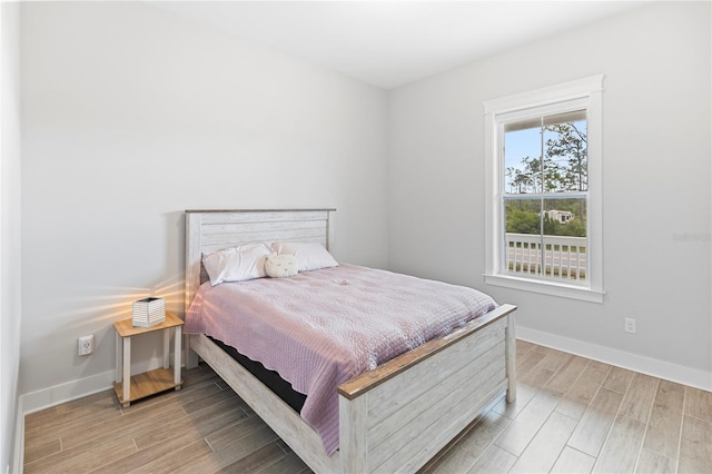 bedroom featuring wood finished floors and baseboards