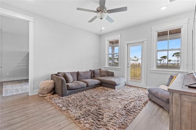 living area featuring plenty of natural light, light wood-type flooring, ceiling fan, baseboards, and recessed lighting