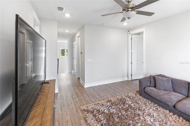 living room featuring recessed lighting, wood finished floors, ceiling fan, and baseboards