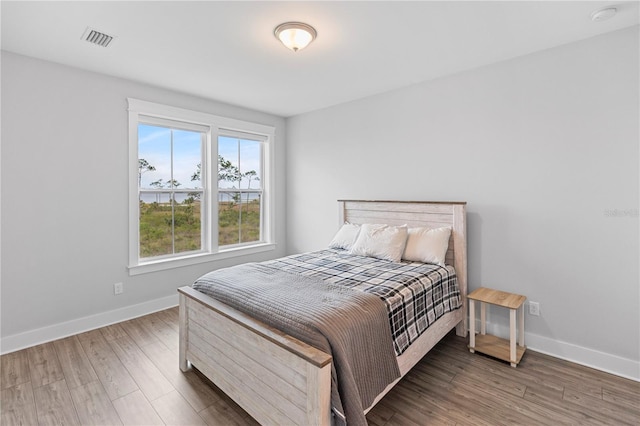 bedroom featuring wood finished floors and baseboards