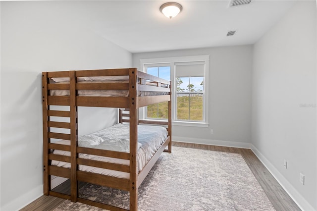 bedroom with wood finished floors and baseboards